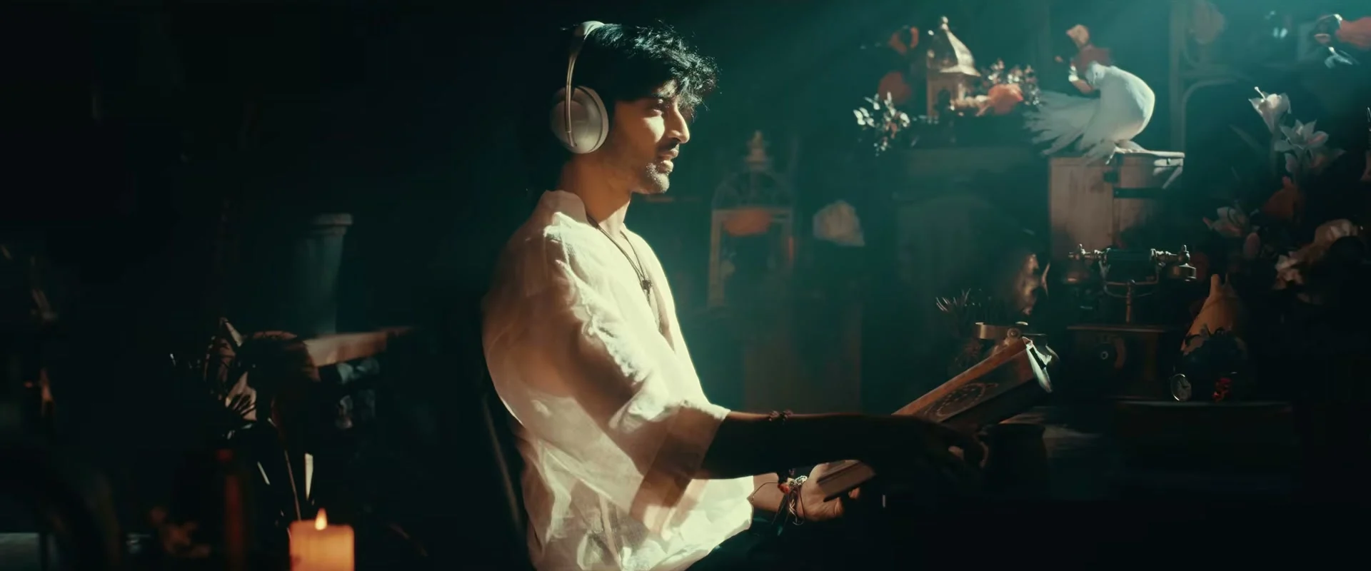 Vivasvaan with headphones and a book in an ornate room